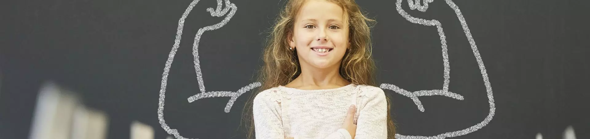 Mädchen In Schule Steht Vor Tafel Mit Muskeln